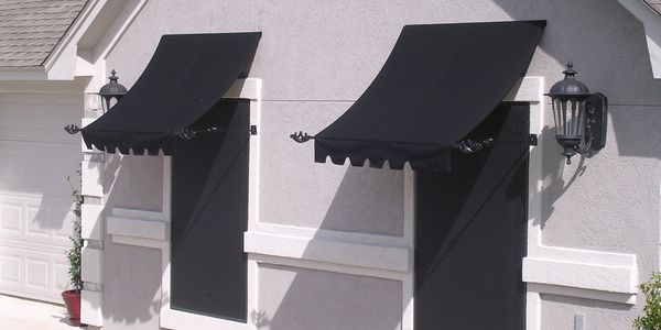 Decorative iron steel awnings black Sunbrella canvas on grey stucco home