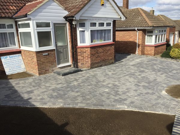 Facade of home with paved walkway leading to the portico and white front door.