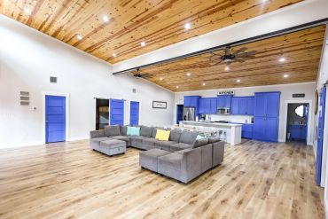 Spacious living room with blue cabinetry and wooden ceiling.