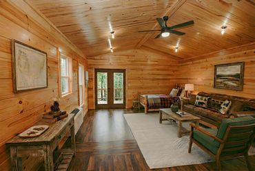 Cozy rustic cabin interior with wooden walls, ceiling, and vintage furnishings.