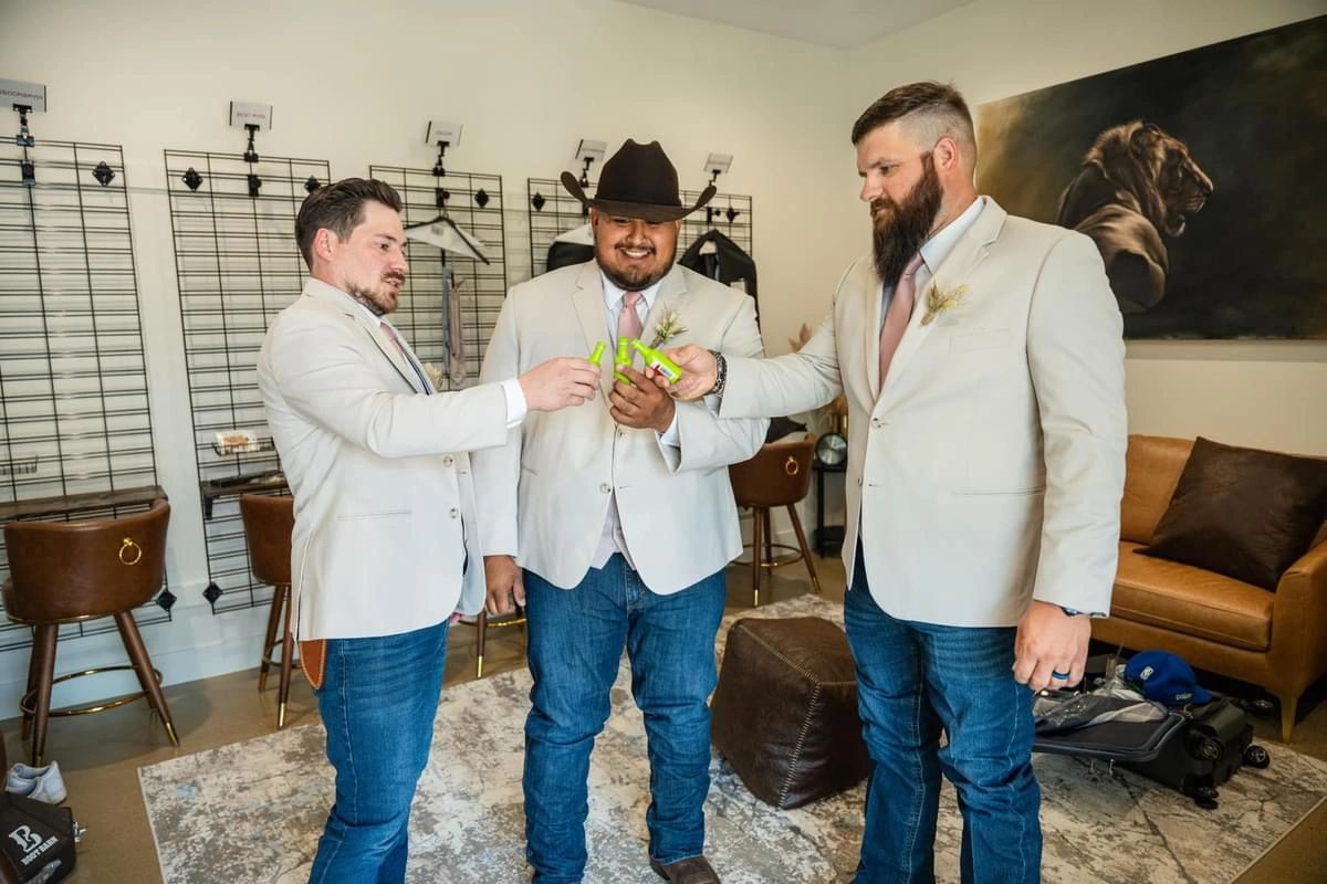 Groomsmen celebrating with a shot in the groom suite in Dallas. Groomsmen celebrating with a shot in the groom suite at your East Texas wedding venue near me.
