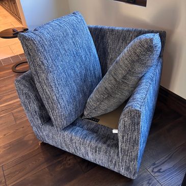 Unique twisted blue armchair with cushions.