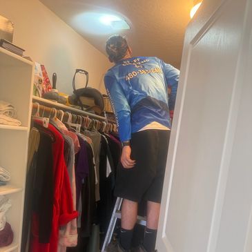 Person in closet fixing a light.