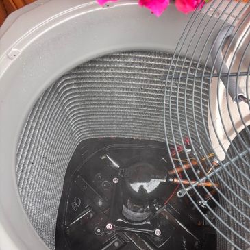 Close-up of an air conditioner's internal coil and fan assembly.