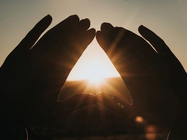 A man holding the hands and sea on the evening sunshine