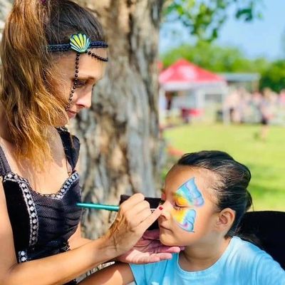 Joy face painting a little girl.