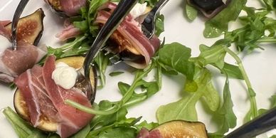 Appetizer spoons with prosciutto, figs, goat cheese, and arugula.