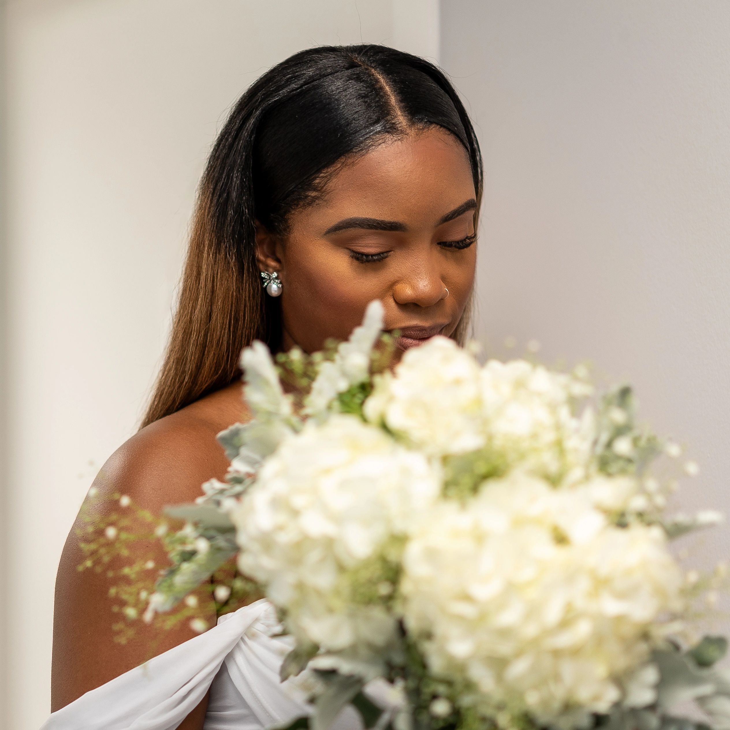 Woman with long hair admiring a bouquet of flowers.