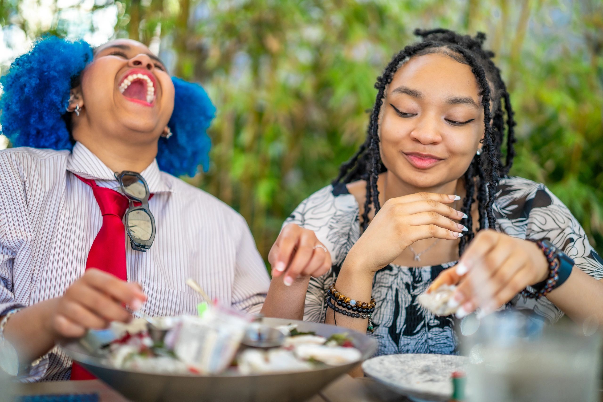 Two friends enjoying food and laughing together.