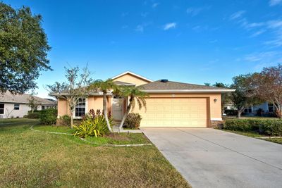 Single-story house with a two-car garage and palm tree in the front yard.