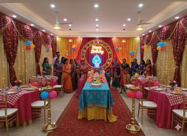 Colorful birthday party setup with family and friends posing.