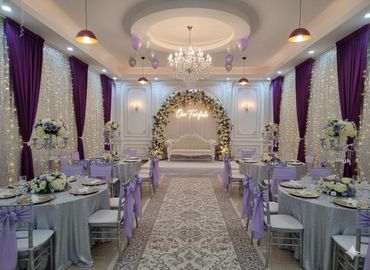 Elegant wedding hall decorated with purple and silver accents.