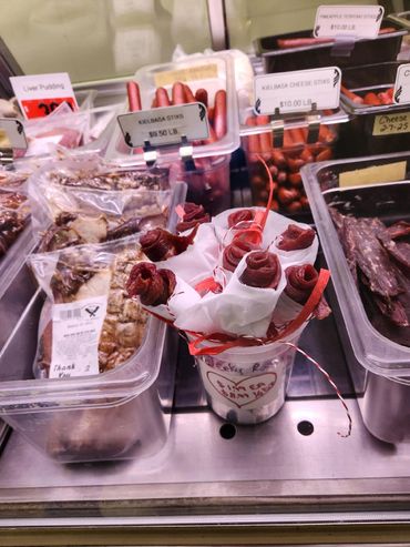 Display of various sausages and jerky at a deli counter.