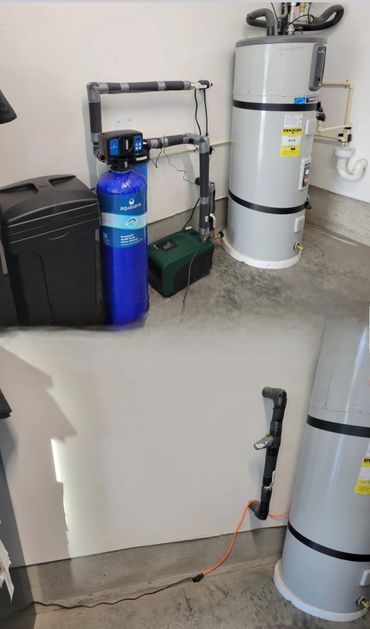 Water filtration and heating system installed in a utility room.