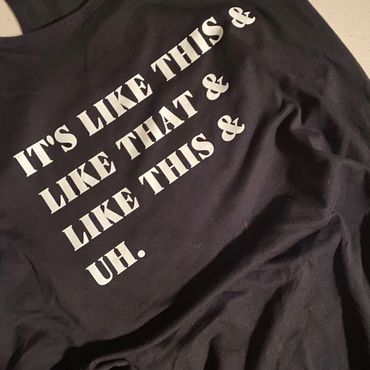 Black fabric with white text reading a repetitive phrase ending in 'uh.'