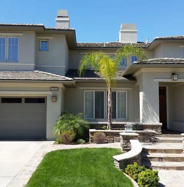 Large modern home with tan stone accents.