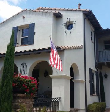White stucco house with an American flag.