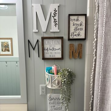 Wall décor and a hanging basket on bead board in a bathroom