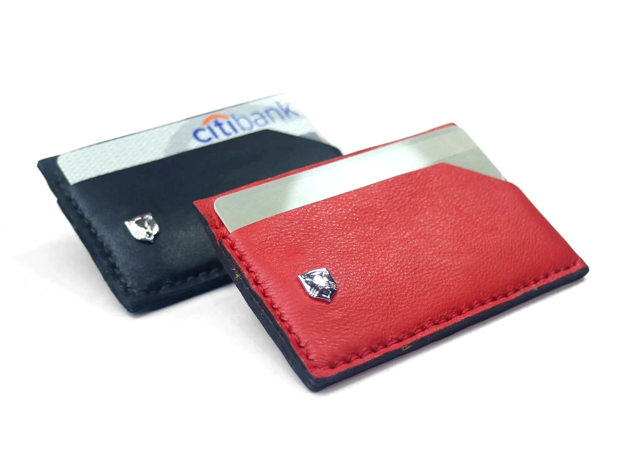Two sleek leather card holders, one red and one black, each holding credit cards.