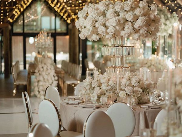 Elegant wedding reception setup with white roses and warm fairy lights.