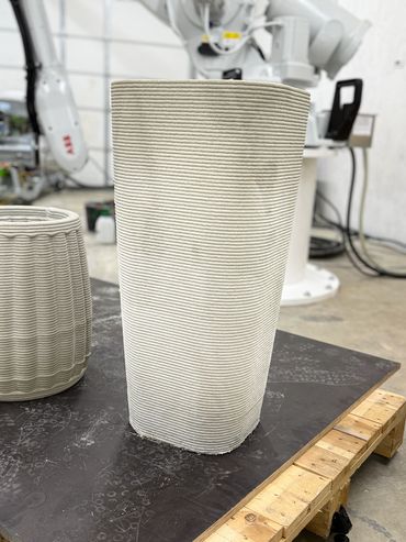 This flower pot is 33 inches tall and has a straight line to it.