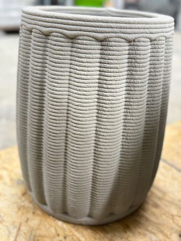 This flower pot has a round top and looks like a hot air balloon.