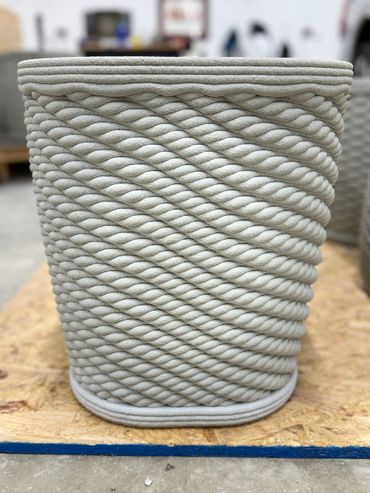 This flower pot has a square top and a twist to it.