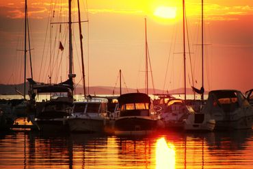 A stunning sunset fills the sky with vibrant orange and pink as the sun sinks below the horizon.