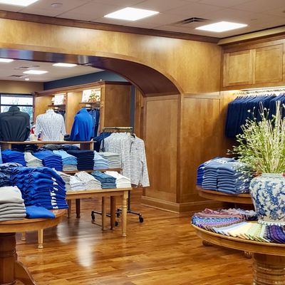 Men's clothing store with beautiful medium stained wood millwork and retail fixtures throughout.