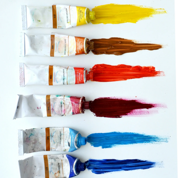 Oil paints being squeezed across white palette neatly in a vertical row.