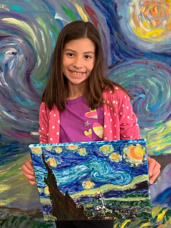 Young child happy with her painting of Van Gogh's Starry Night