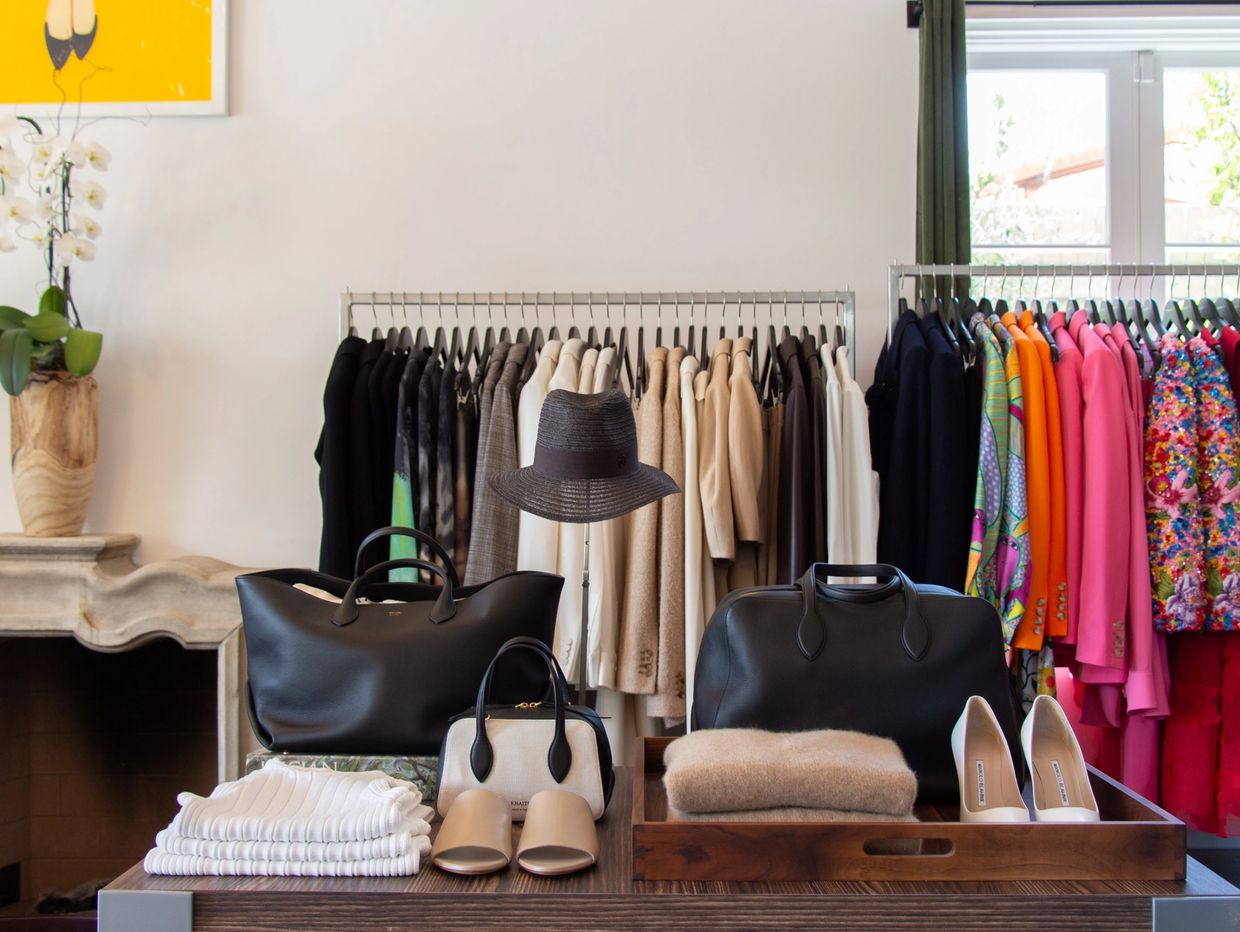 Luxury handbags, shoes, and clothing displayed in a chic boutique.