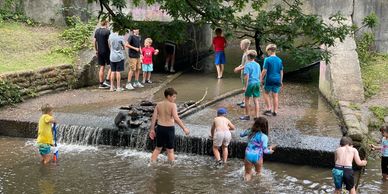 Image of kids have fun in a river whilst on a Campmates Single Parent holiday.