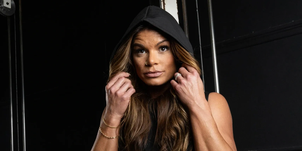 Confident woman in a hooded sleeveless top.