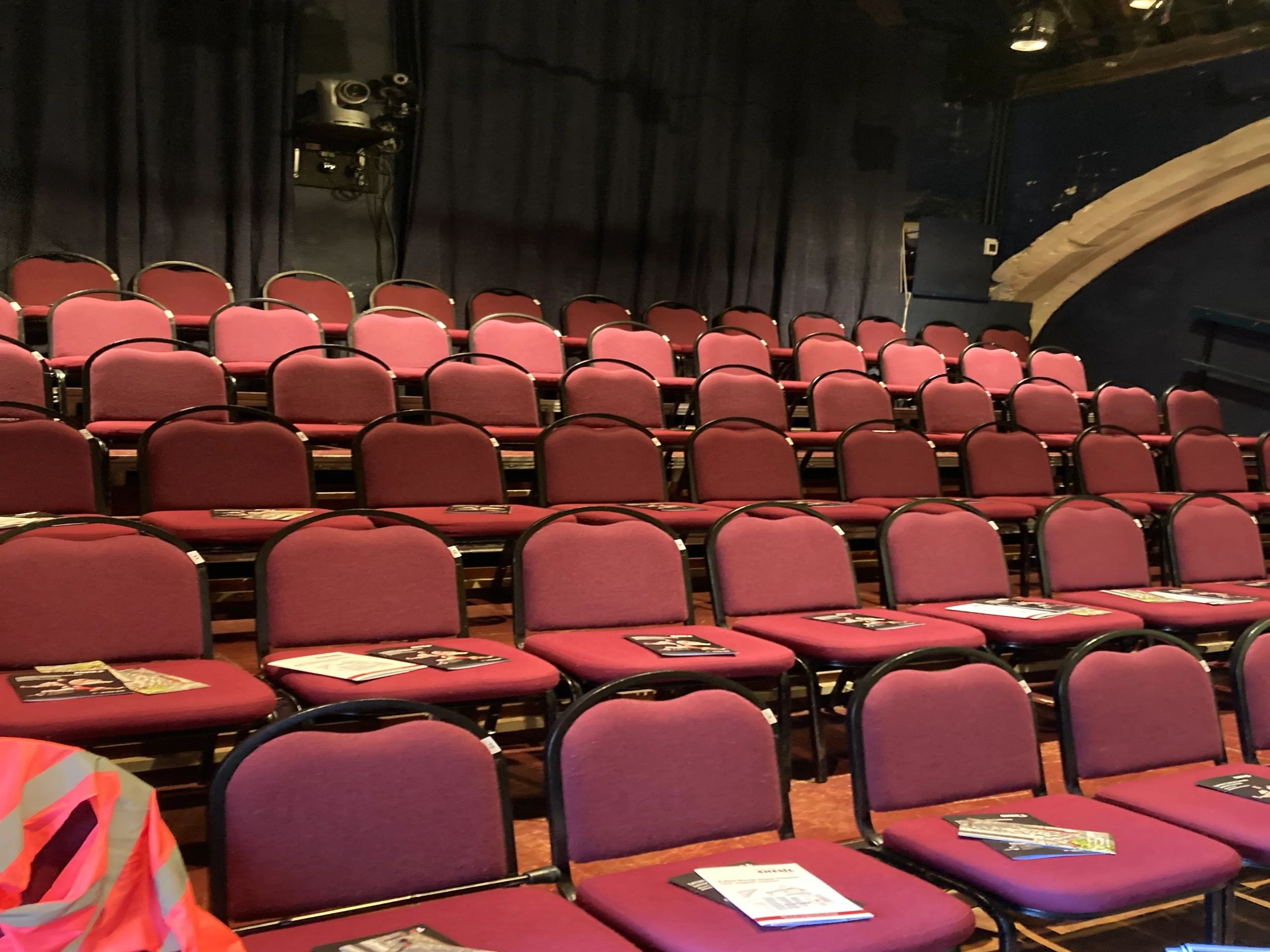 Empty theater seats with programs placed on them.
