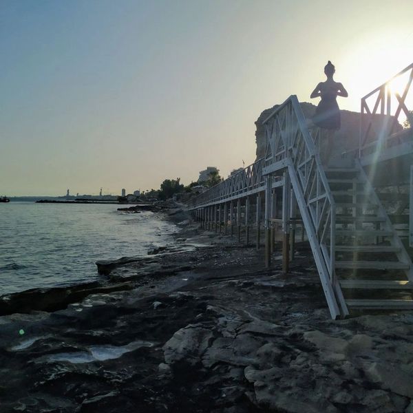 junge Frau in Yogaposition am Strand in Limassol Zypern mit Sonneneinstrahlung