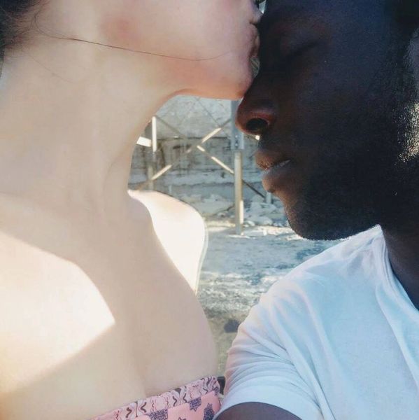 junge Frau küsst dunkelschäutigen jungen Mann auf die Stirn am Strand in Limassol Zypern