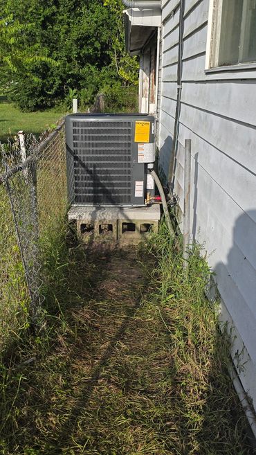 Outdoor air conditioning unit next to house.