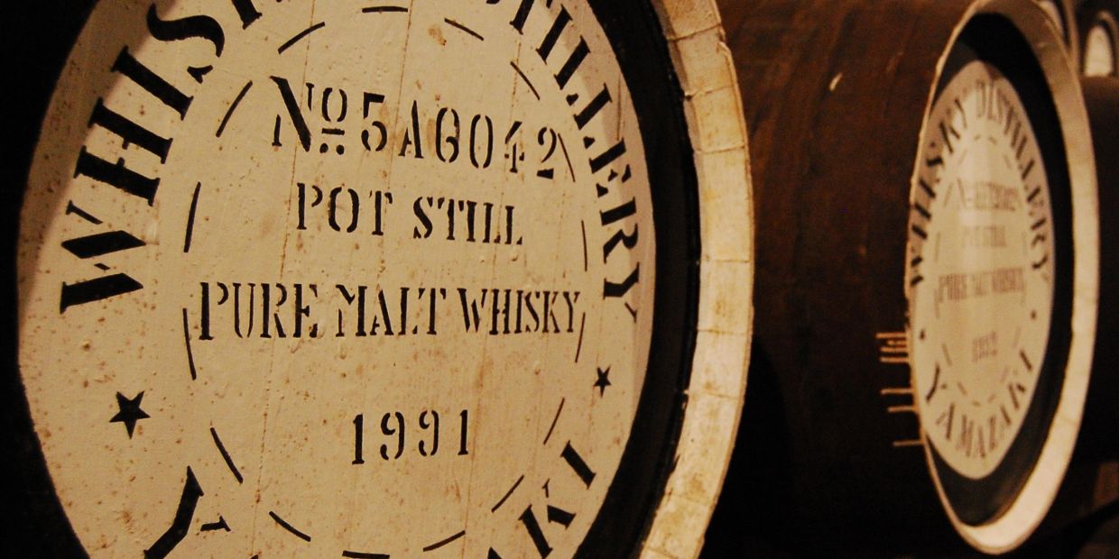 Close-up of whisky barrels labeled with details.