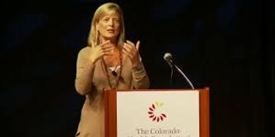 Woman speaking at a podium during a conference.