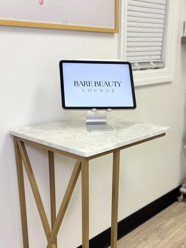 Bare Beauty Lounge logo displayed on iPad inside a private waxing Studio in Commack, Long Island, NY