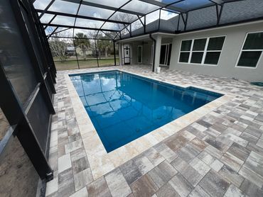 Modern screened pool enclosure with clean blue water and tiled deck.