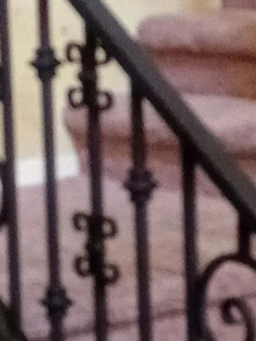Custom interior wrought iron stair and Balcony railing with ornamental scrollwork in a residential h