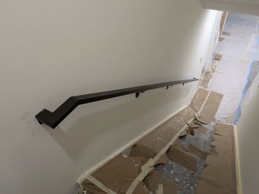 Modern interior steel wall-mounted handrail for residential stairs.