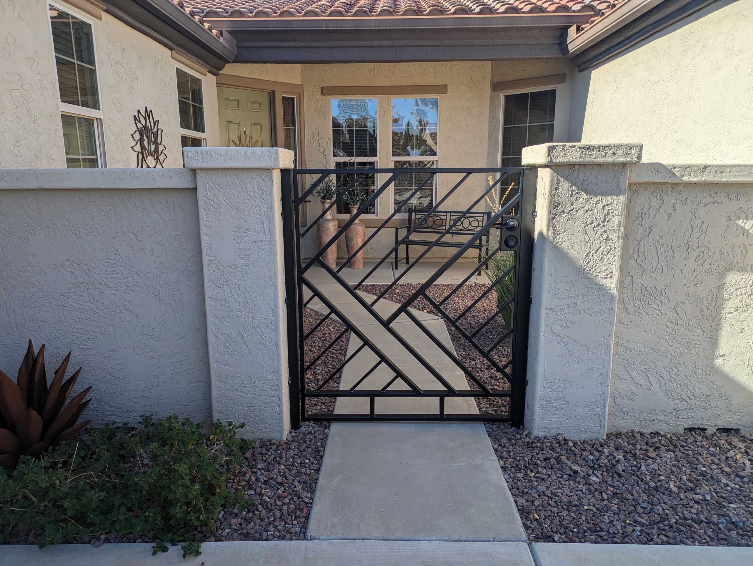 Front view of a patio with a metal gate and walkway.