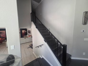 Custom interior steel stair railing with modern square pickets and matching handrail.