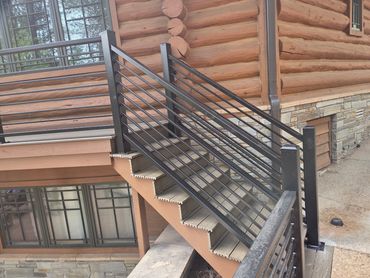 Horizontal steel stair railings for a mountain log home.