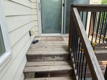 Before picture of before small deck with wood railing.