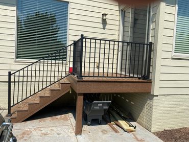After picture of new small deck with black railing.
