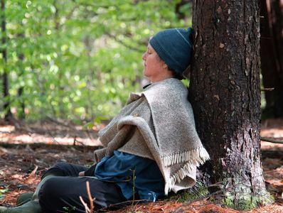 woman resting against tree